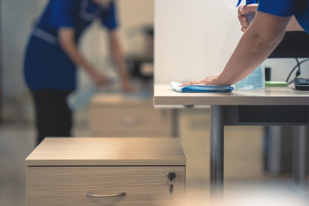 Hand of the cleaner cleans the office table.Cleaning concept.