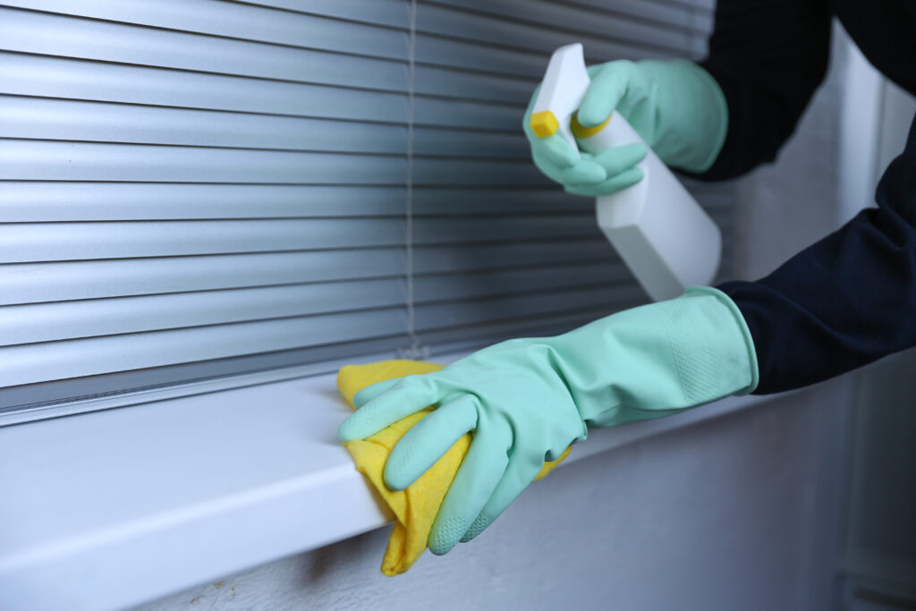 cleaner's hands in rubber mint gloves doing disinfection cleanin