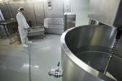 Cleaning at Food Factory High angle background image of female worker washing equipment at clean food production factory, copy space