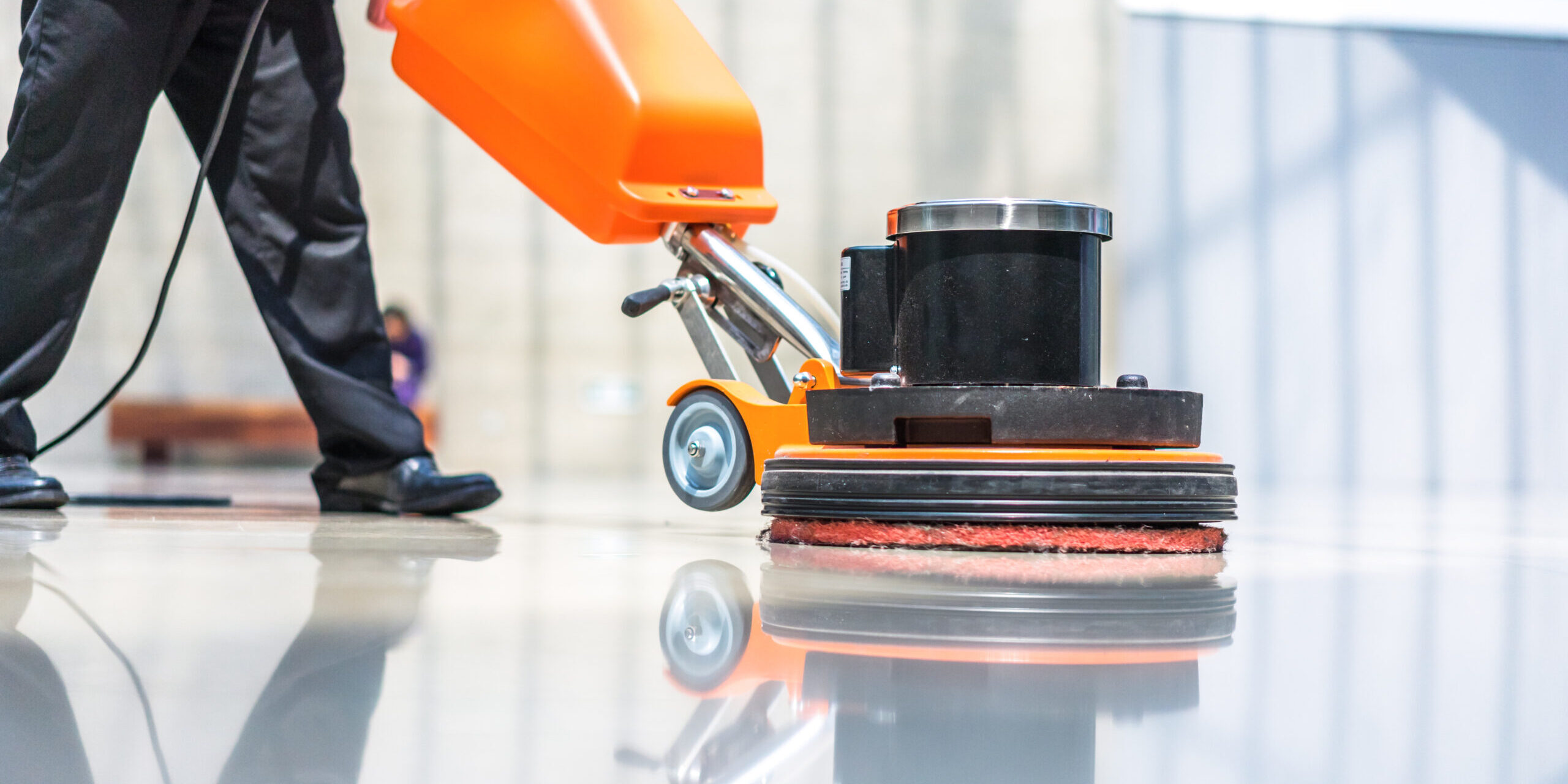 A person cleaning the floor with a machine